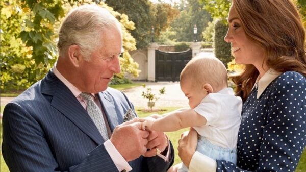 King Charles meeting a baby being held by Kate Middleton