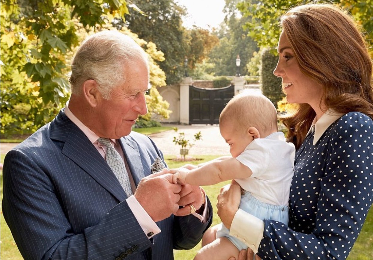 King Charles meeting a baby being held by Kate Middleton